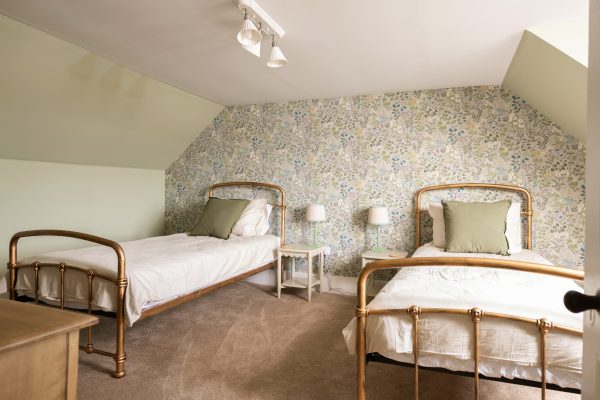 Lovely vintage style single beds complete this twin bedroom