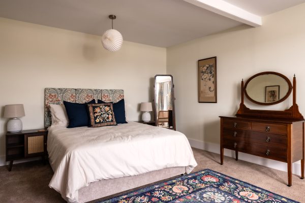 Master bedroom with king sized bed, tastefully decorated.