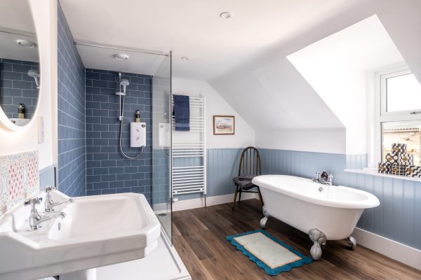 Roll-top bath is the feature of this luxury bathroom, complete with walk in shower.